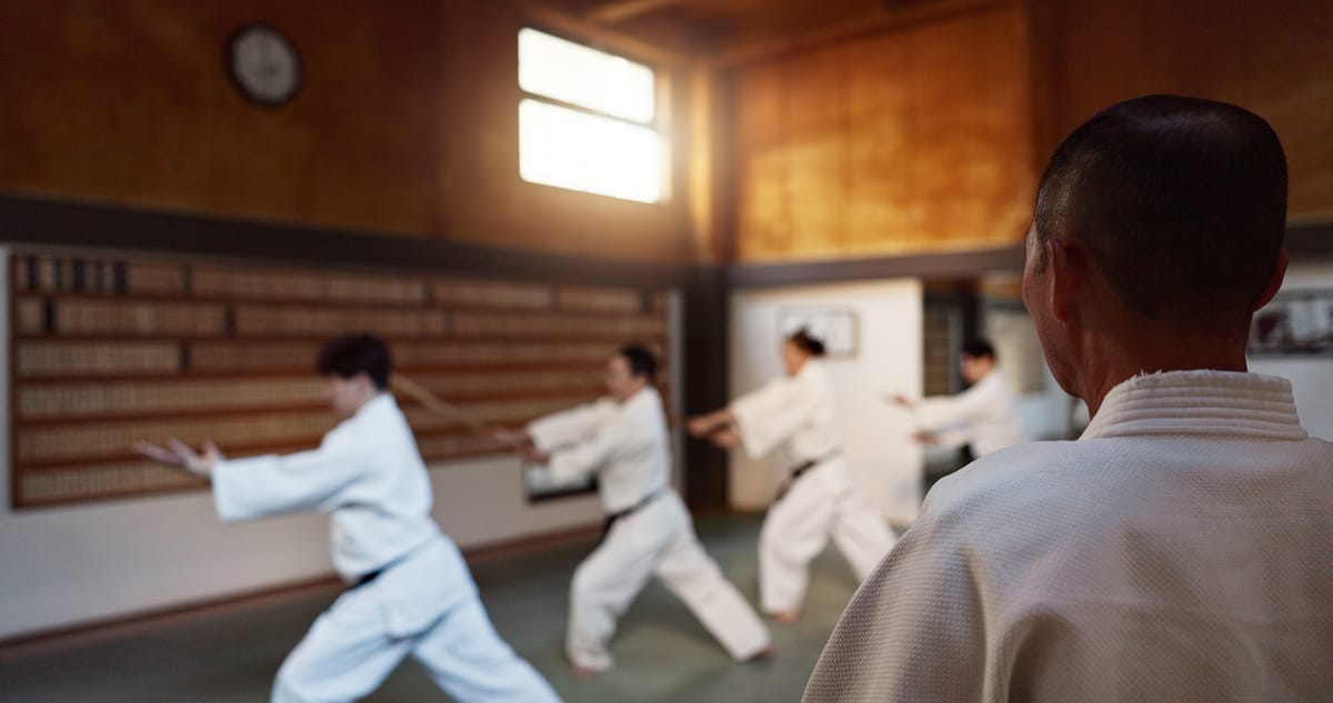 An instructor guiding a student through technique on the mats
